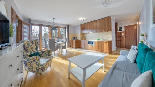 een woonkamer met een bank en een tafel bij Rozewie, Sun & Snow in Jastrzębia Góra