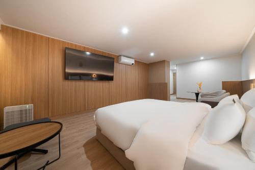 a bedroom with a white bed and a flat screen tv at Cheonan H-Avenue Cheonan Buldang in Cheonan