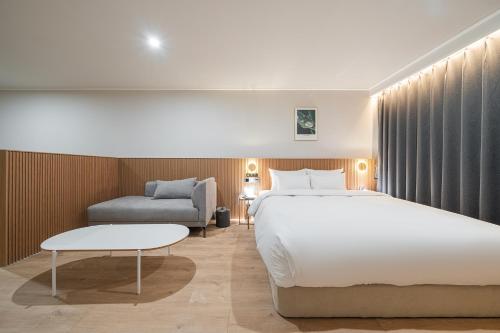 a hotel room with a bed and a couch at Cheonan H-Avenue Cheonan Buldang in Cheonan