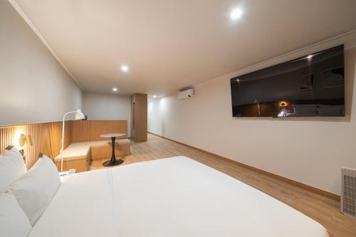 a hotel room with a bed and a tv on the wall at Cheonan H-Avenue Cheonan Buldang in Cheonan