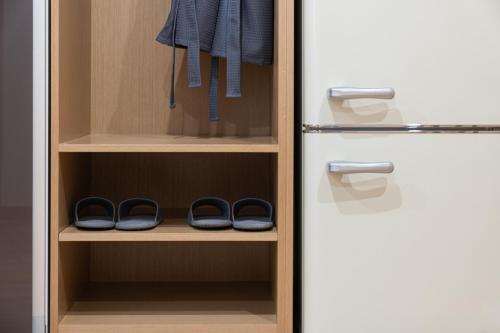 a pair of shoes in a closet next to a refrigerator at Cheonan H-Avenue Cheonan Buldang in Cheonan