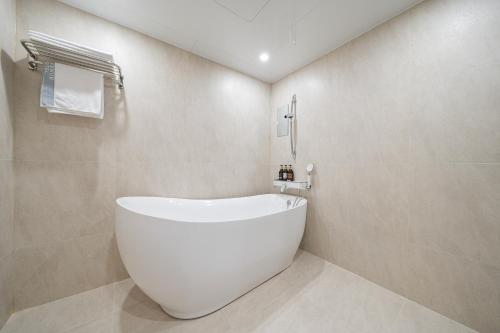 a bathroom with a white bath tub in a room at Cheonan H-Avenue Cheonan Buldang in Cheonan