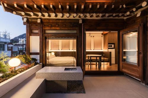 a room with a bed and a table on a balcony at Luxury Hanok Stay in Breeze in Seoul