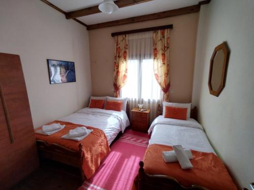a bedroom with two twin beds and a window at Mprizis Rooms in Elati Trikalon