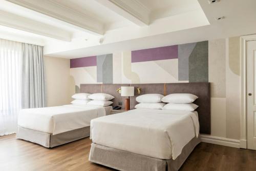 a bedroom with two beds and a colorful wall at Buenos Aires Marriott in Buenos Aires