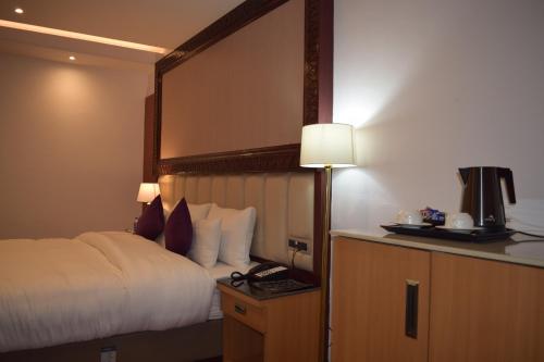a hotel room with a bed and a lamp at Hotel The Haven - Centrally Heated and Air Conditioned in Kargil