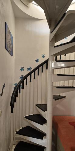 a staircase with black and white stairs in a room at Kenzia in Agnone Bagni