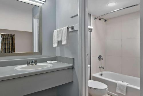 a white bathroom with a sink and a toilet at Motel 6 McDonough, GA in McDonough