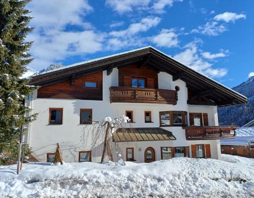 a large white building with a balcony in the snow at Haus Oberluggauer in Wald am Arlberg