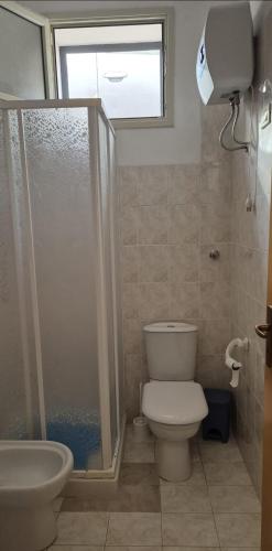 a bathroom with a toilet and a shower and a sink at Kenzia in Agnone Bagni