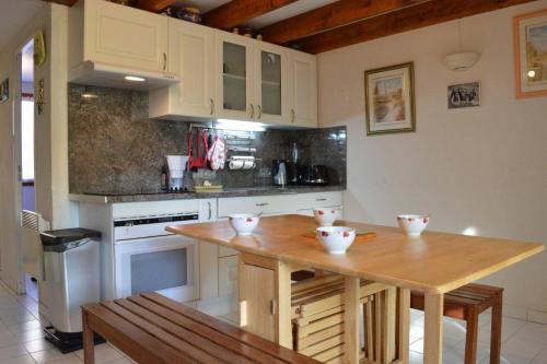 - une cuisine avec une table en bois et des bols dans l'établissement Maison 3 pièces mezzanine 8 couchages sc105-013, à Saint Cyprien Plage