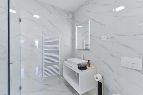 een witte badkamer met een wastafel en een spiegel bij Villa DIV with pool in Bibinje