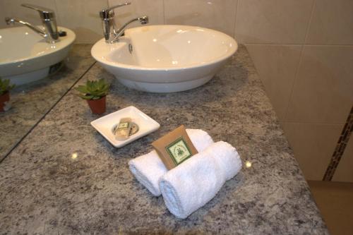 Un mostrador de baño con un lavabo y una toalla. en Milawa Muscat Retreat B&B, en Milawa