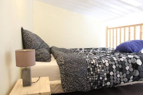 une chambre avec un lit avec des oreillers noirs et blancs dans l'établissement Appt Studio mezza LA ROCHELLE - LR180-291, à La Rochelle
