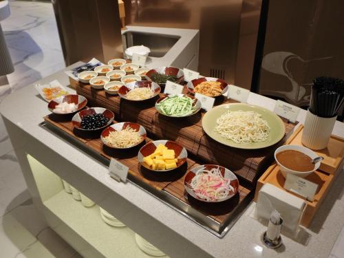 a buffet with bowls of food on a counter at Hotel Royal-Nikko Taipei in Taipei