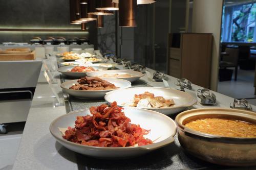 a buffet line with plates of food on a counter at Hotel Royal-Nikko Taipei in Taipei