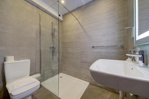a bathroom with a toilet and a sink and a shower at Kuya -Private 2BR Penthouse with Pool & Sunbeds By JL in Is-Swieqi
