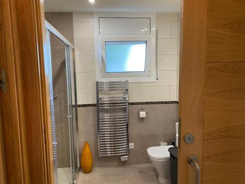 a small bathroom with a toilet and a window at El Valles Apartment sea view in Llança