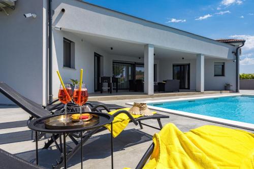 a patio with a table next to a swimming pool at Villa Speranza with Illuminated Pool in Pula