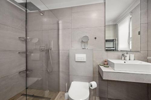 a bathroom with a shower and a toilet and a sink at Villa Speranza with Illuminated Pool in Pula