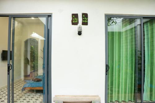 a door to a room with green curtains at Sea For Rest Homestay in Xuân Dục