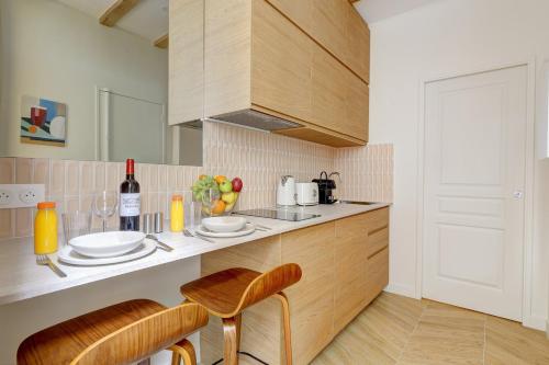 une cuisine avec un comptoir, une table et des chaises dans l'établissement TBS 304 - Charming studio in Paris, à Paris