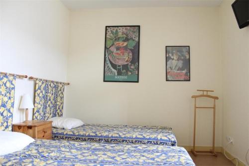 une chambre avec deux lits et deux tableaux au mur dans l'établissement Studio La Rochelle - LR180-010, à La Rochelle