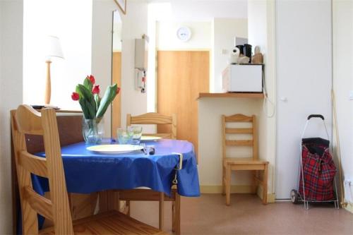 une table avec un chiffon de table bleu et un vase de fleurs. dans l'établissement Studio La Rochelle - LR180-010, à La Rochelle