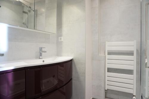 une salle de bain avec un lavabo et un miroir dans l'établissement Rue Saint Saens - Paris 15, à Paris