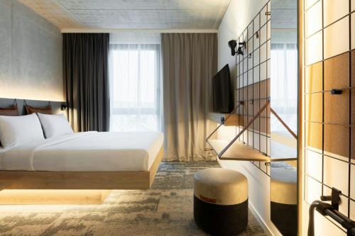 a hotel room with a bed and a window at Moxy Hamburg - Finkenwerder in Hamburg