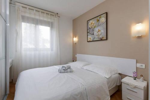 una camera da letto bianca con un letto bianco e una finestra di Apartment Luce a Spalato (Split)