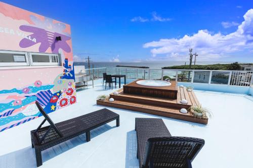 a balcony with two chairs and a table on a yacht at Coral Sea Villa OKINAWA MIYAKOJIMA in Miyako-jima