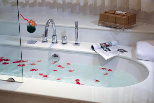 una bañera con un lavabo con flores. en Kodchasri Thani Hotel Chiangmai, en Chiang Mai