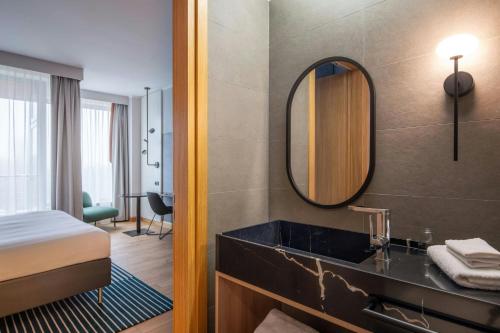 a bathroom with a sink and a bed and a mirror at Sopot Marriott Resort & Spa in Sopot