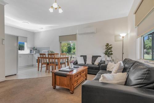 a living room with a couch and a table at Murray River Resort in Moama