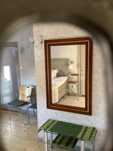 a mirror in a room with a table and a chair at Villa Madame in Väderstad