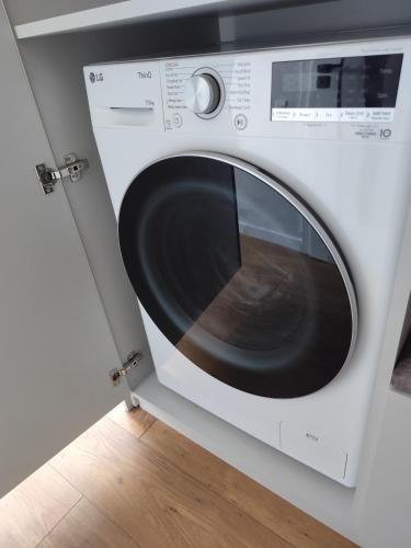 a white washing machine sitting in a room at Itaja apartment 73 in Šiauliai