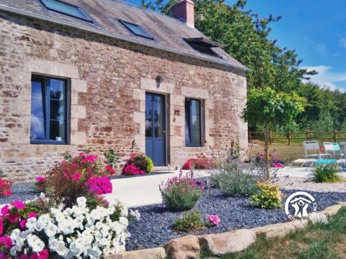 a stone house with flowers in front of it at La petite vallée in Saint-Calais-du-Désert