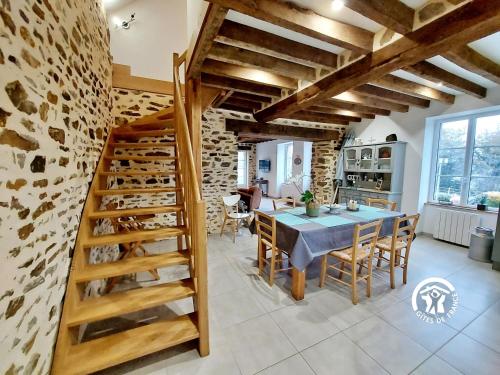 une cuisine et une salle à manger avec une table et un escalier dans l'établissement La petite vallée, à Saint-Calais-du-Désert
