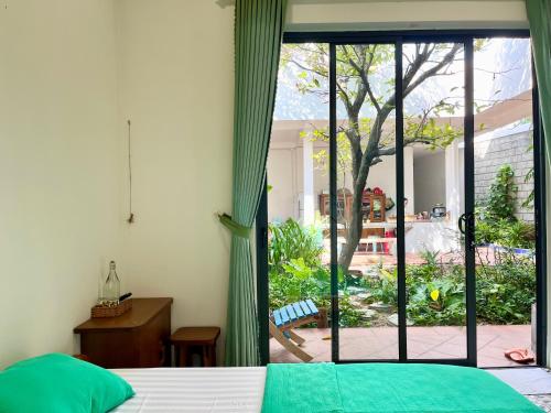 a bedroom with a bed and a sliding glass door at Sea For Rest Homestay in Xuân Dục