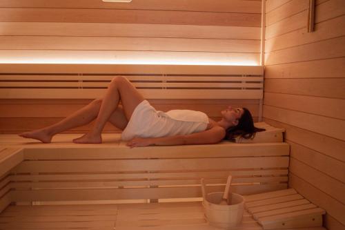 a woman is laying in a sauna at Hotel CUBE Prague in Prague
