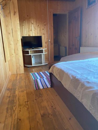 a bedroom with a bed and a flat screen tv at Під Явором in Vorokhta