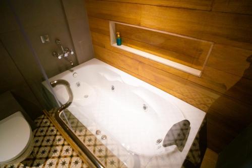a bathroom with a bath tub next to a toilet at Casa Bonita Prime rose in Khanivde