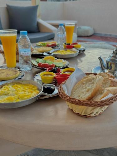a table with breakfast foods and drinks on it at Playa Surf House in Tamraght Ouzdar