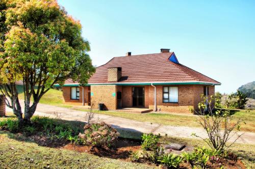 a brick house with a tree in front of it at Mogodi Lodge in Graskop