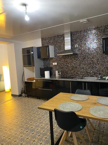 une cuisine avec une table, deux chaises et un comptoir dans l'établissement Gîte Travailleurs de La Somme, à Mons-en-Chaussée