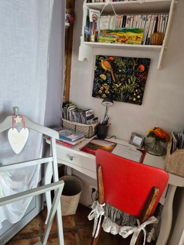 a bedroom with a desk and a red chair at Gite de charme 3* in Saint-Esteben