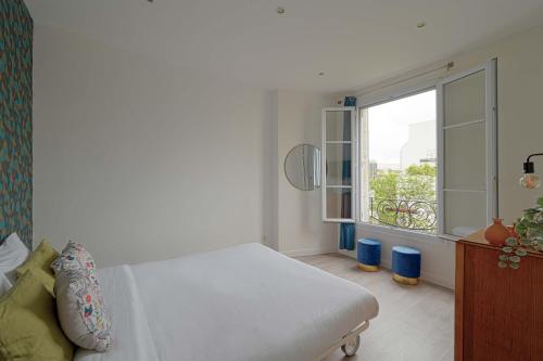 una camera da letto con un letto e una grande finestra di Appartement idealement localise a Boulogne a Boulogne-Billancourt