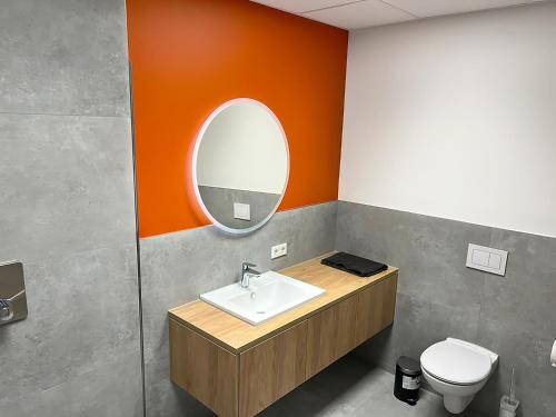 un bagno con lavandino, specchio e WC di Erlebniswelt Resort Apartment 9 a Reken