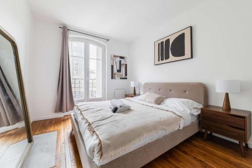 une chambre blanche avec un lit et une fenêtre dans l'établissement Appartement service 2 Pieces au Coeur du 19e - 4P, à Paris